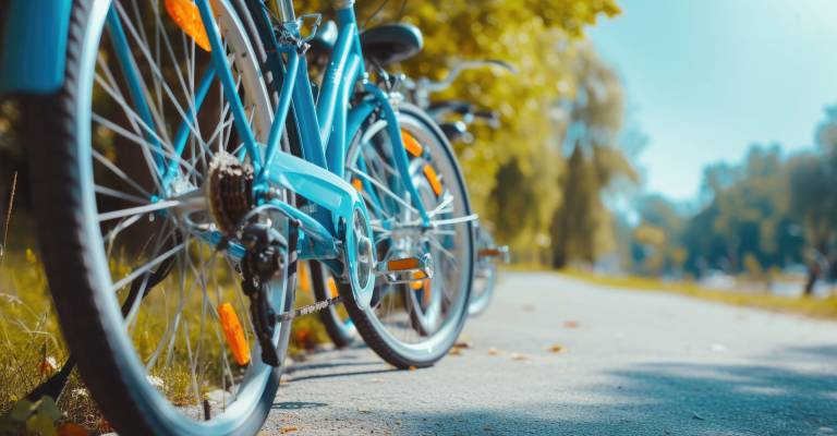 Een close-up van een blauwe fiets geparkeerd aan de kant van een weg.